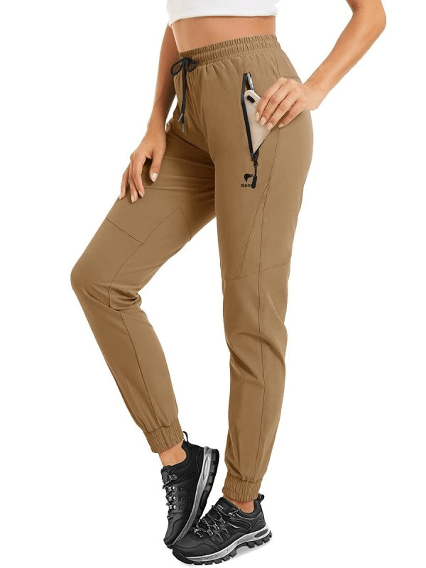Woman wearing travel quick-drying pants with zippered pockets in tan, showcasing comfort and style.